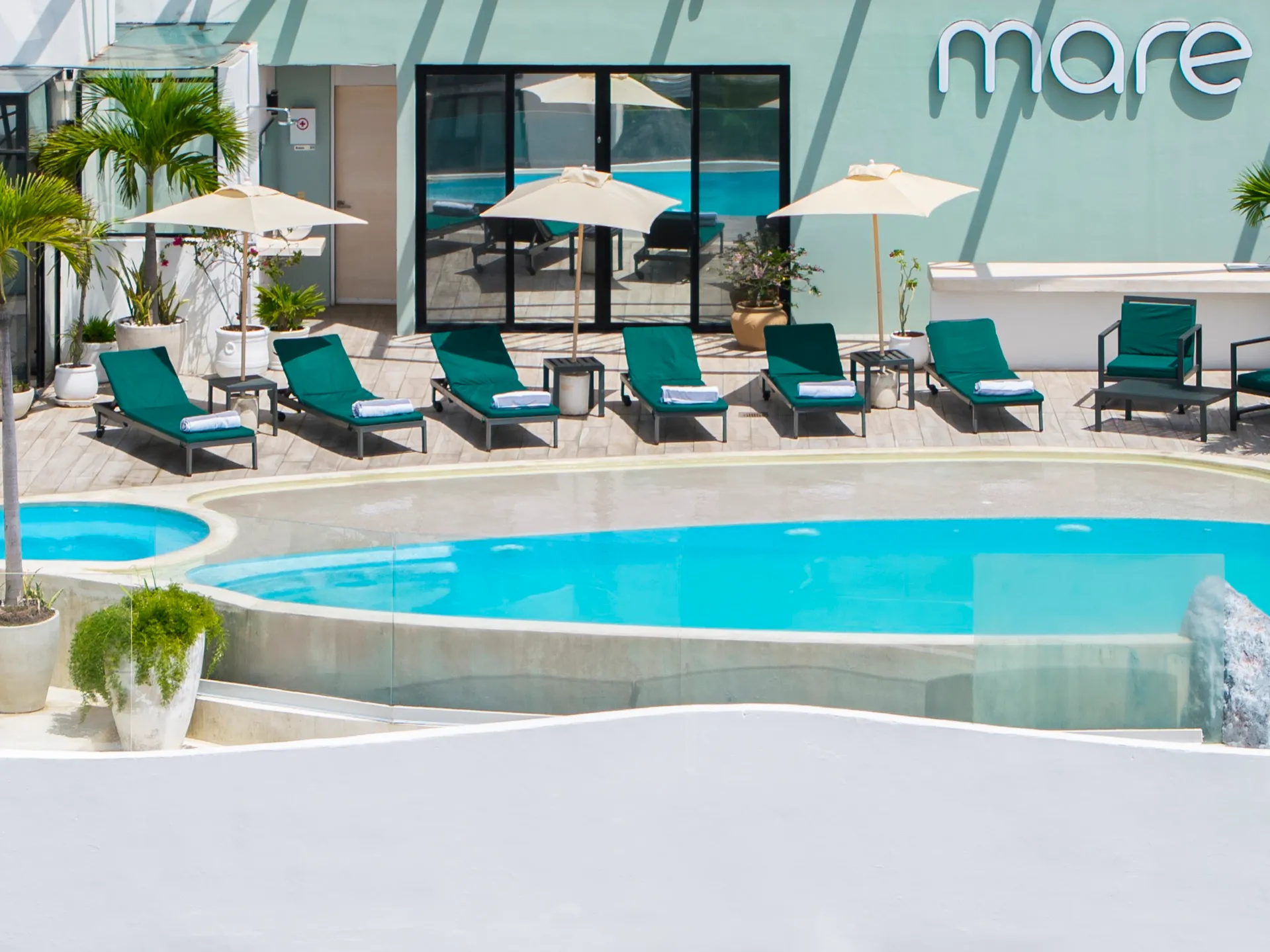 Aerial view of the Mare Condo rooftop: pool, sun loungers and umbrellas