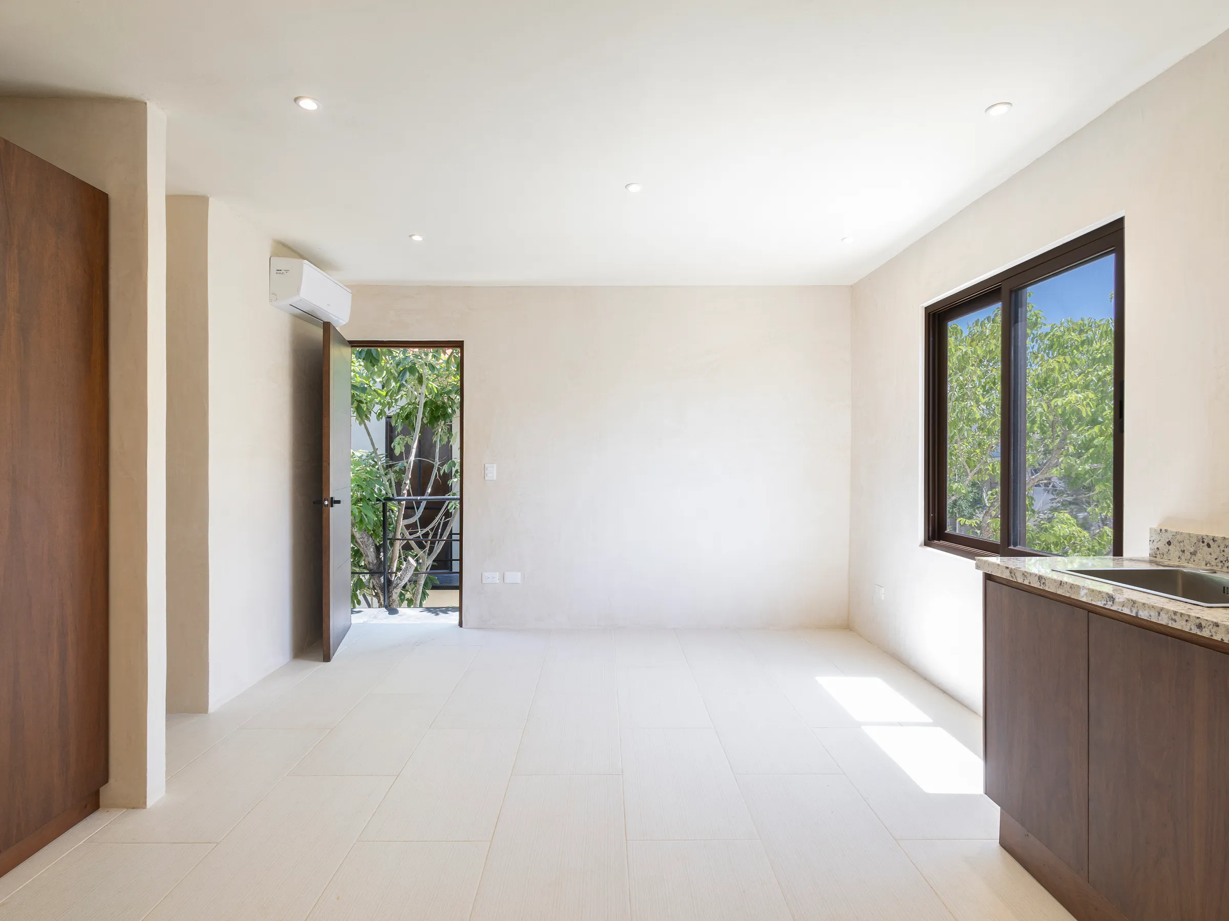 Pièce de la Villa Quetzal avec kitchenette et porte donnant sur l’extérieur