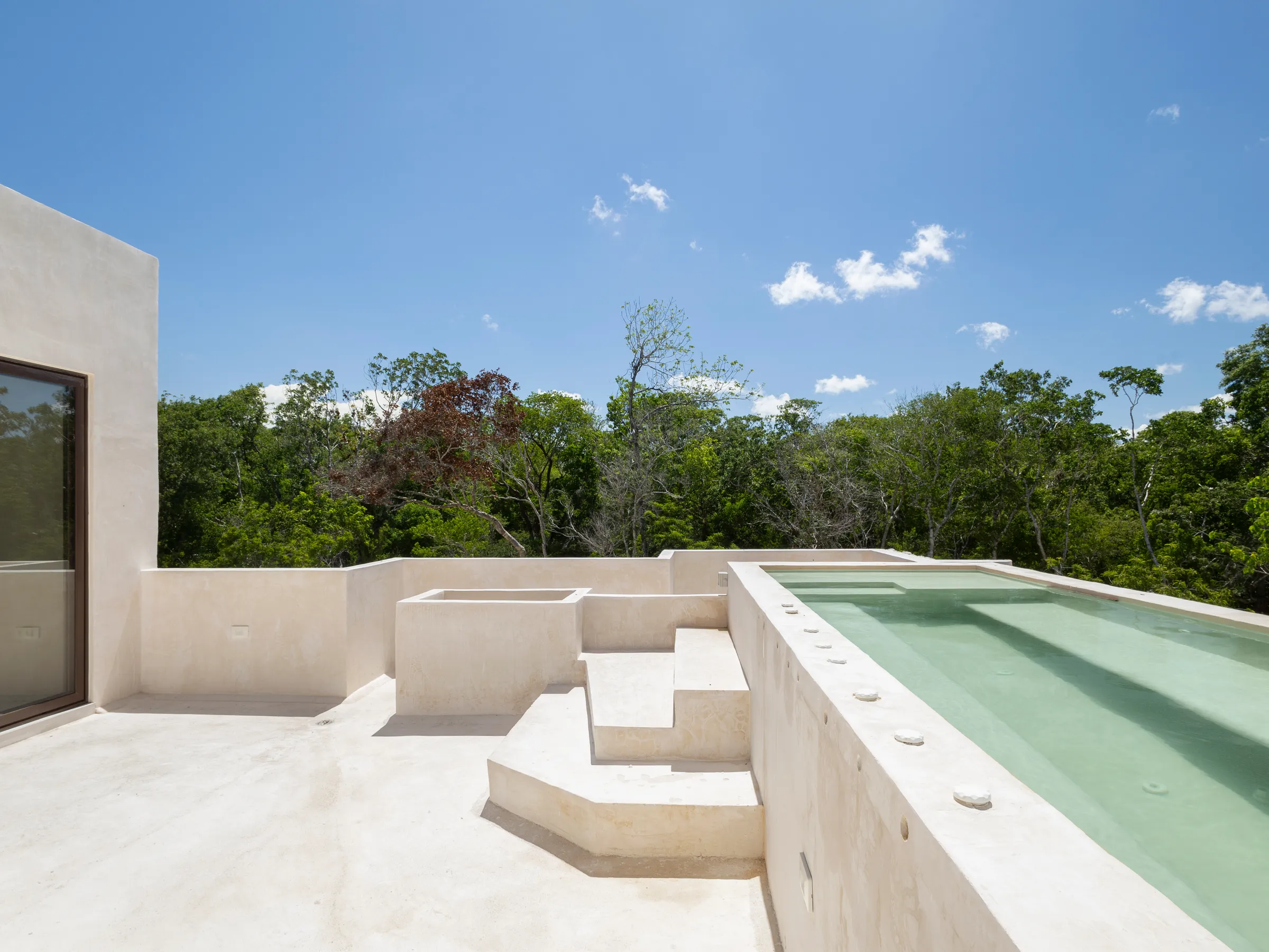 Piscine du troisième étage de la Villa Quetzal avec solarium, entourée de jungle
