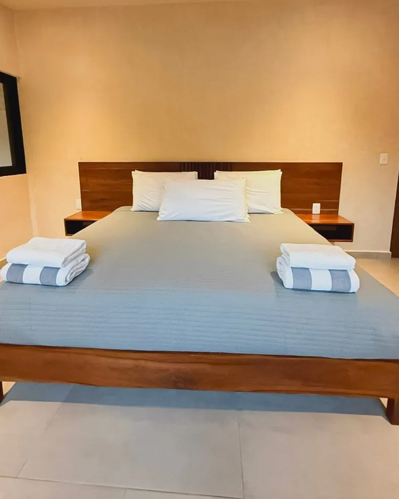 Recámara con cama king y cabecera de madera