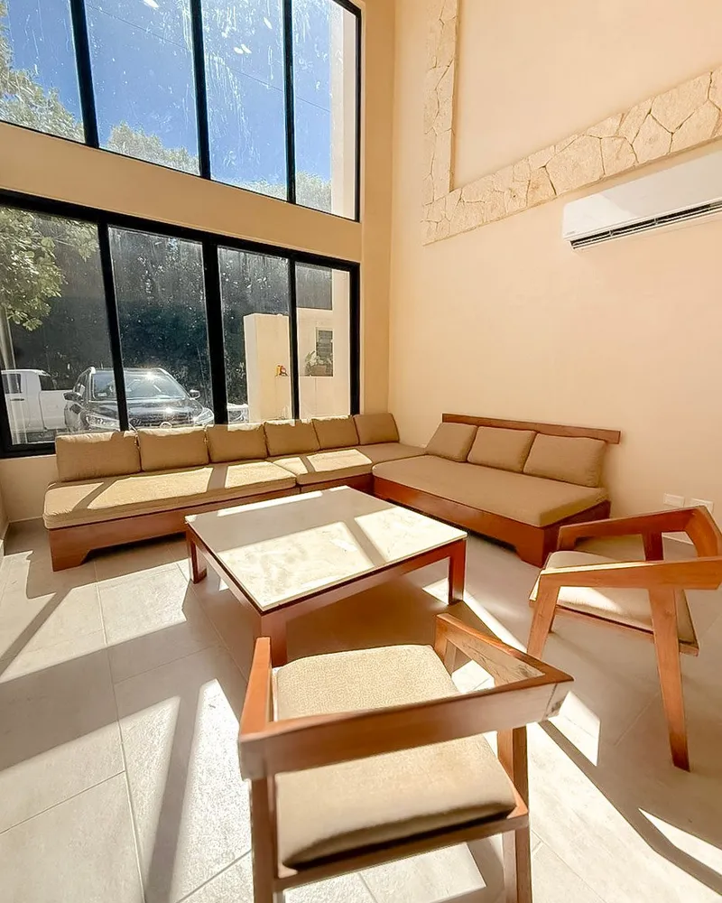 Salon en double hauteur avec baies ouvertes sur la végétation, de jour