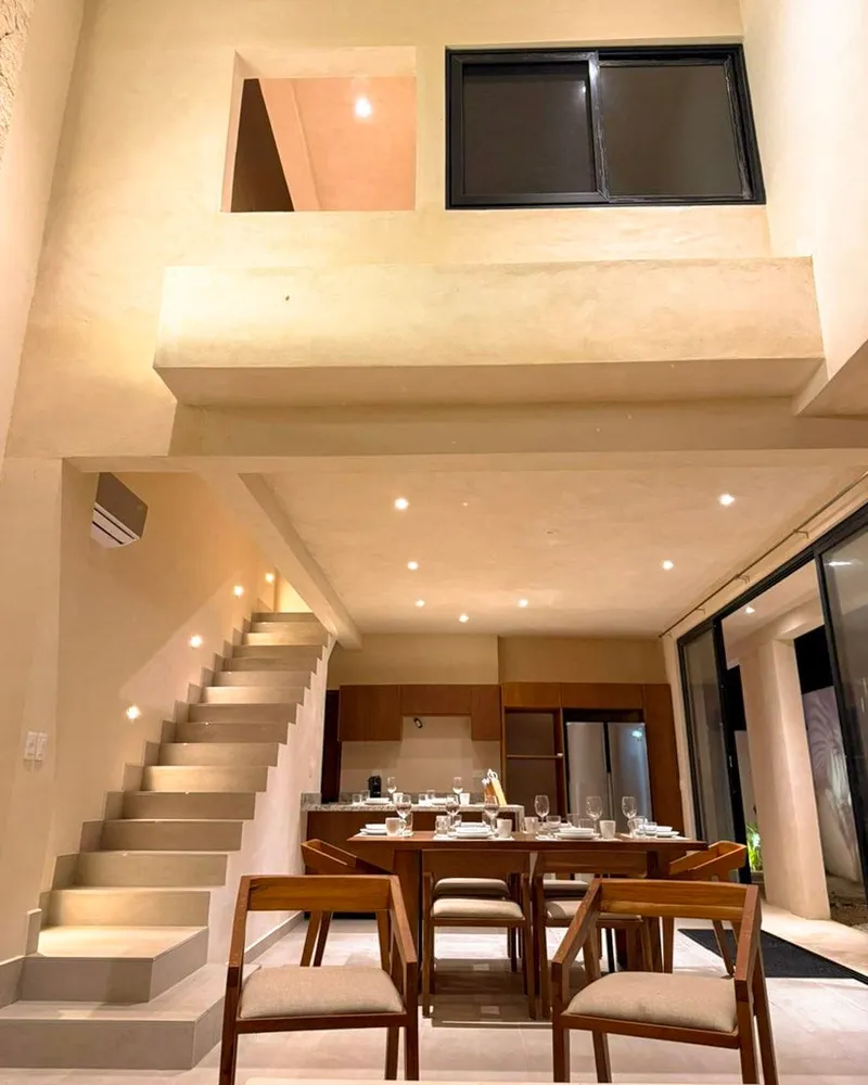 Doble altura con la escalera y el comedor de una villa